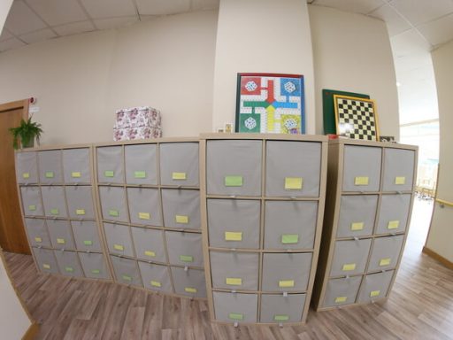 Mueble de almacenamiento con filas de cajones grises y juegos en las paredes.