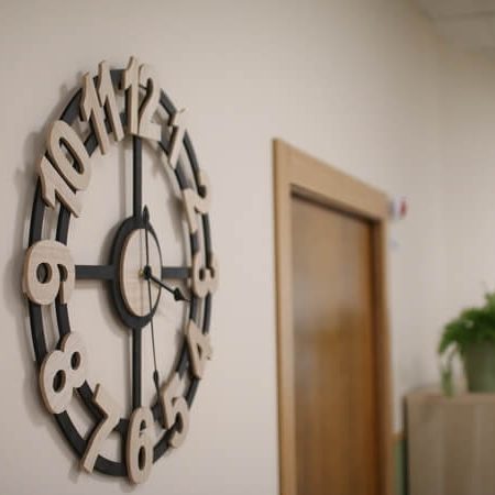Reloj de pared negro con números de madera.
